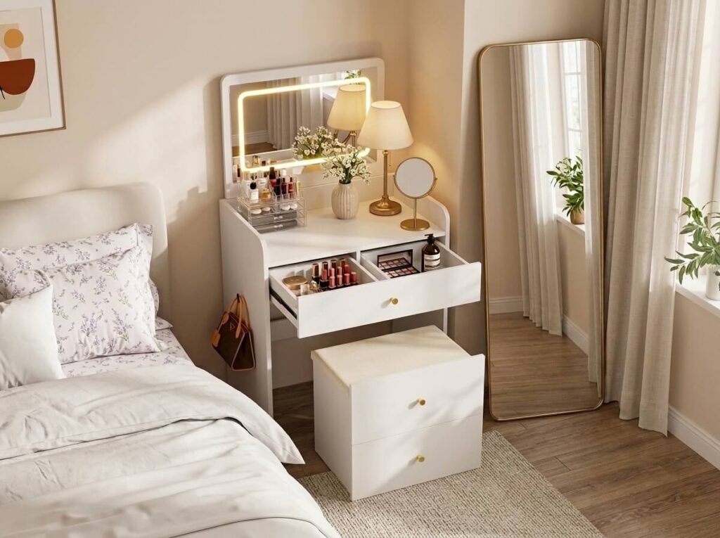 Small bedroom with a compact vanity lighted mirror, makeup organizer and faux flowers in ceramic vase, next to a full length mirror